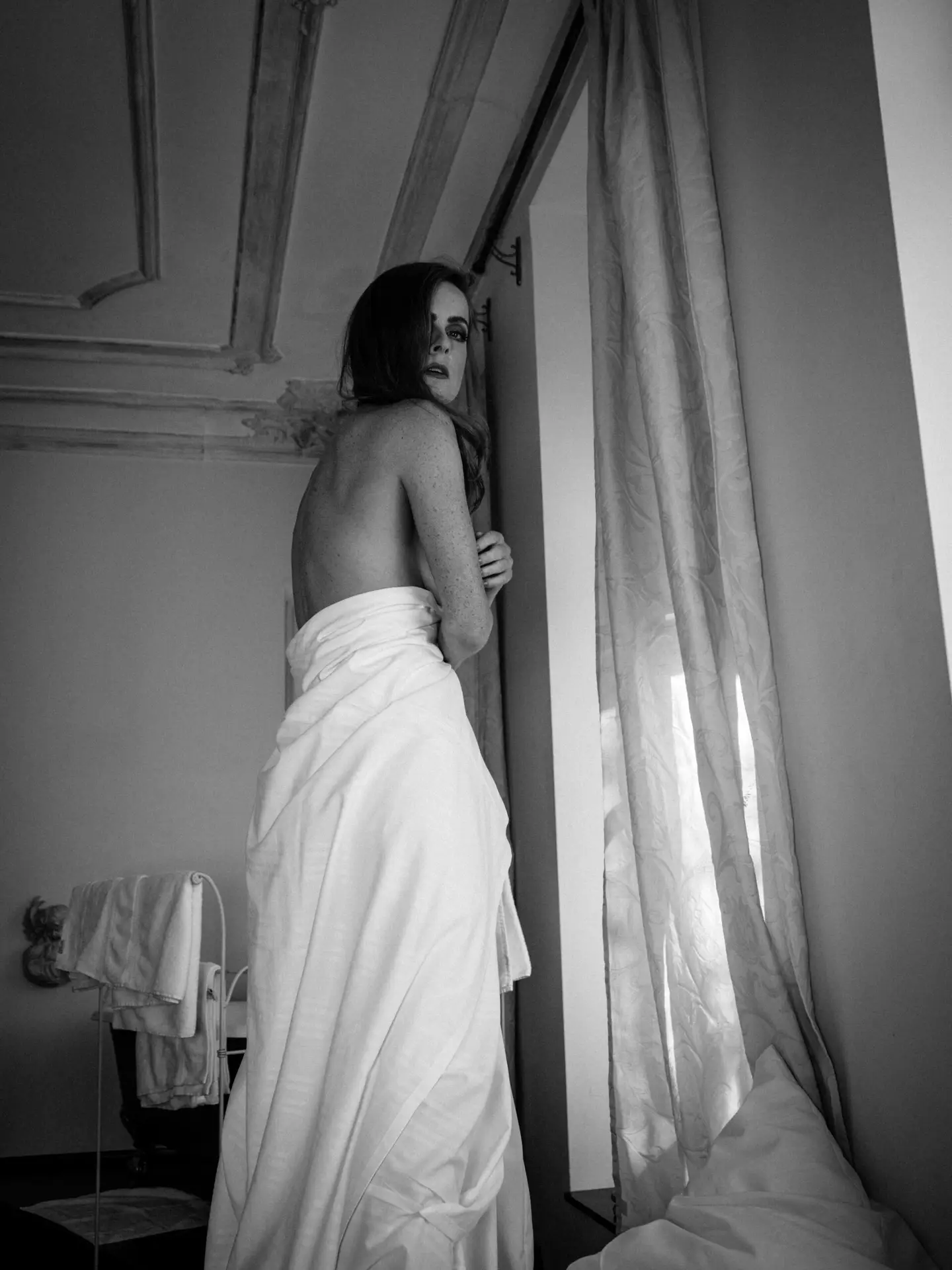 fine art nude black and white woman standing on bed