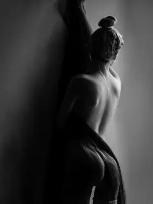 Black and white nude photography showing a woman in velvet stillness, evoking quiet desire, vulnerability, and timeless grace
