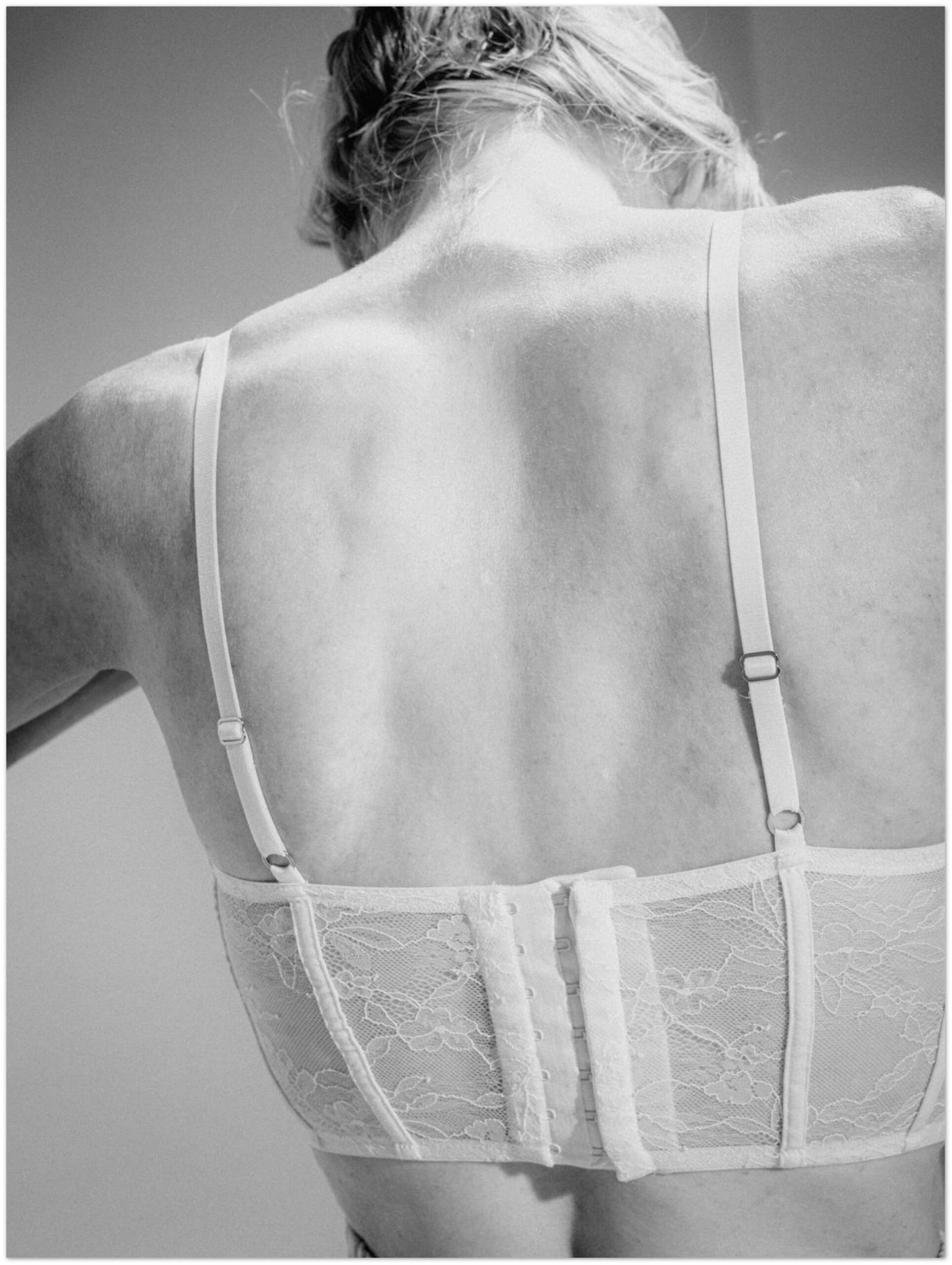 rear view on a woman’s back. She’s wearing a white lingerie top